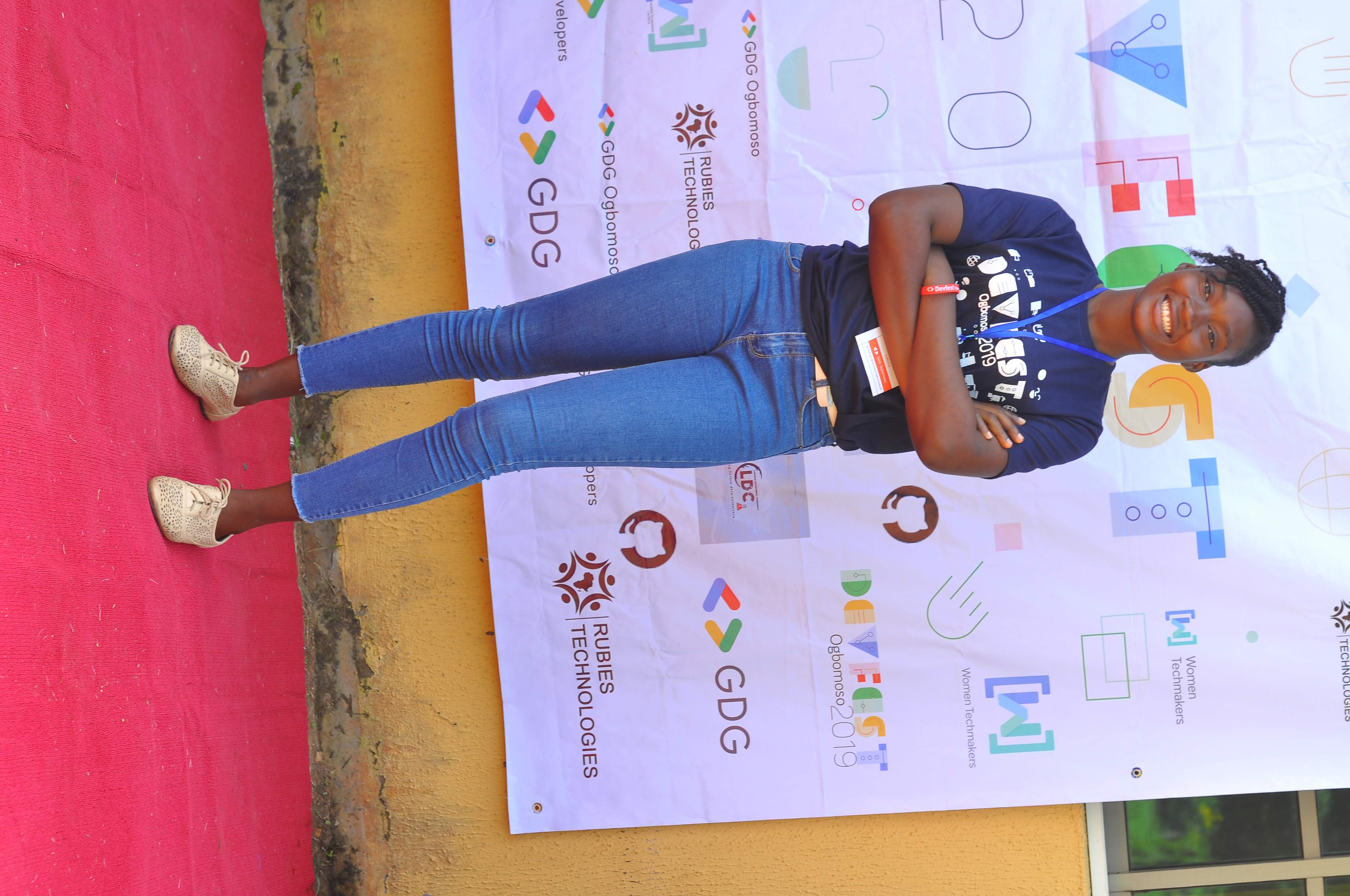 An attendee posing on the red carpet at the photo backdrop at DevFest Ogbomoso 2019