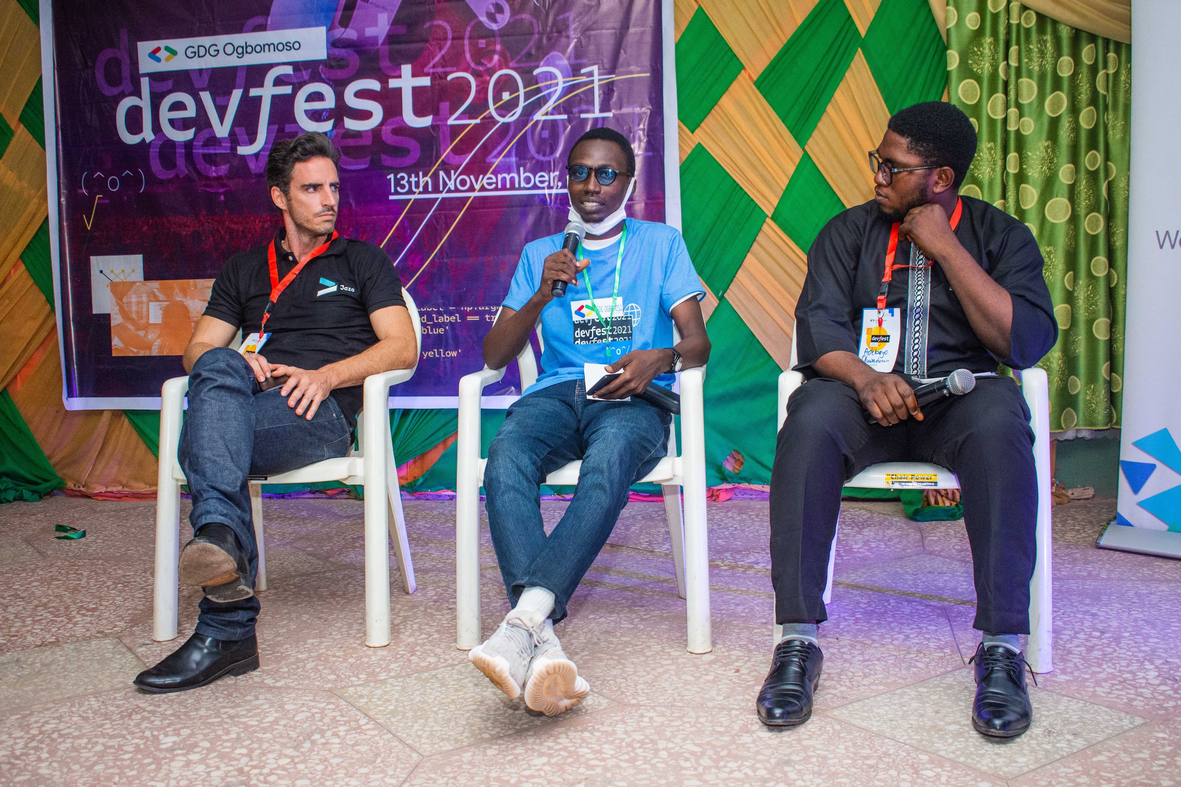 Three panelists seated in front of the DevFest backdrop at DevFest Ogbomoso 2021