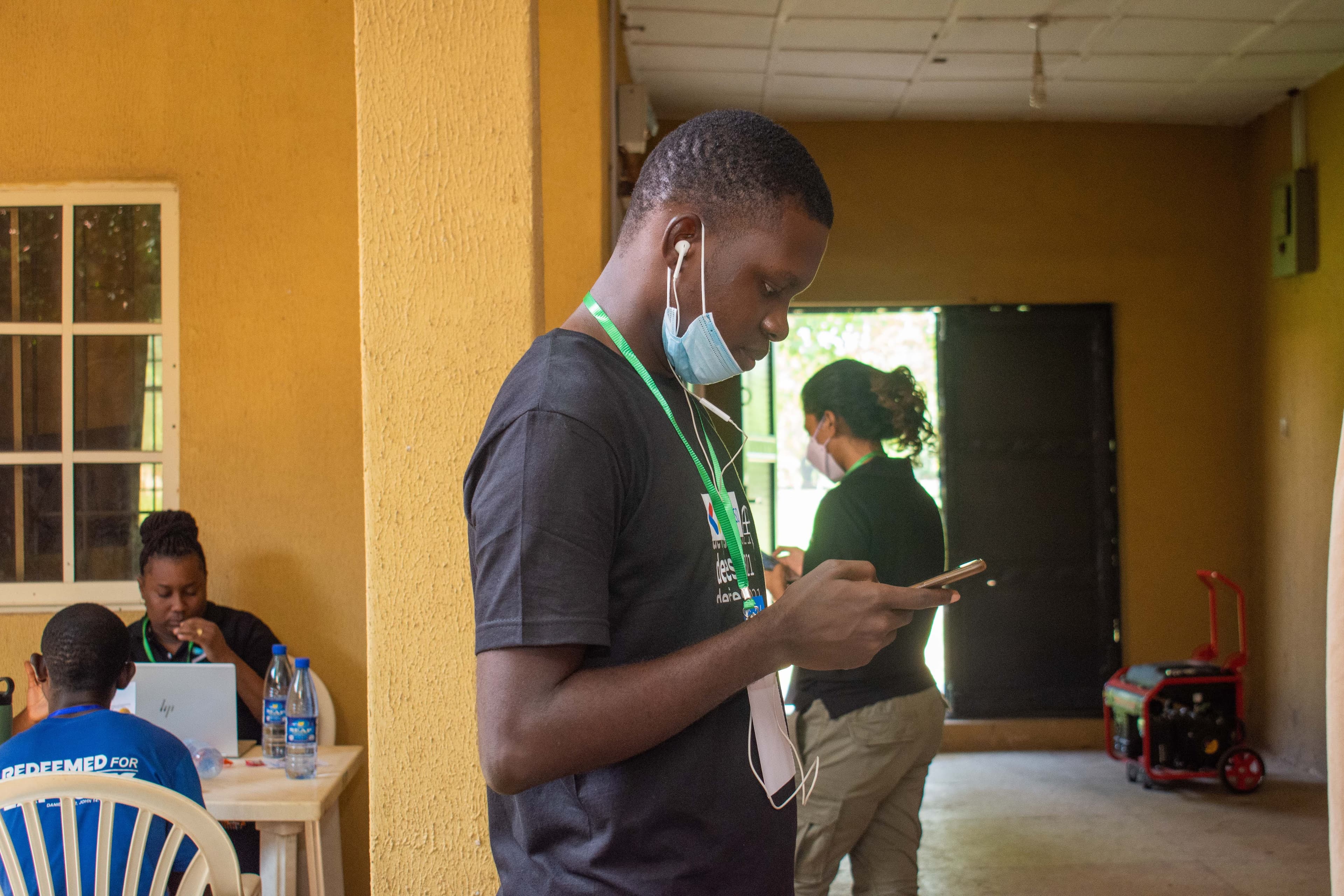 An attendee looking at a phone in a corridor at DevFest Ogbomoso 2021