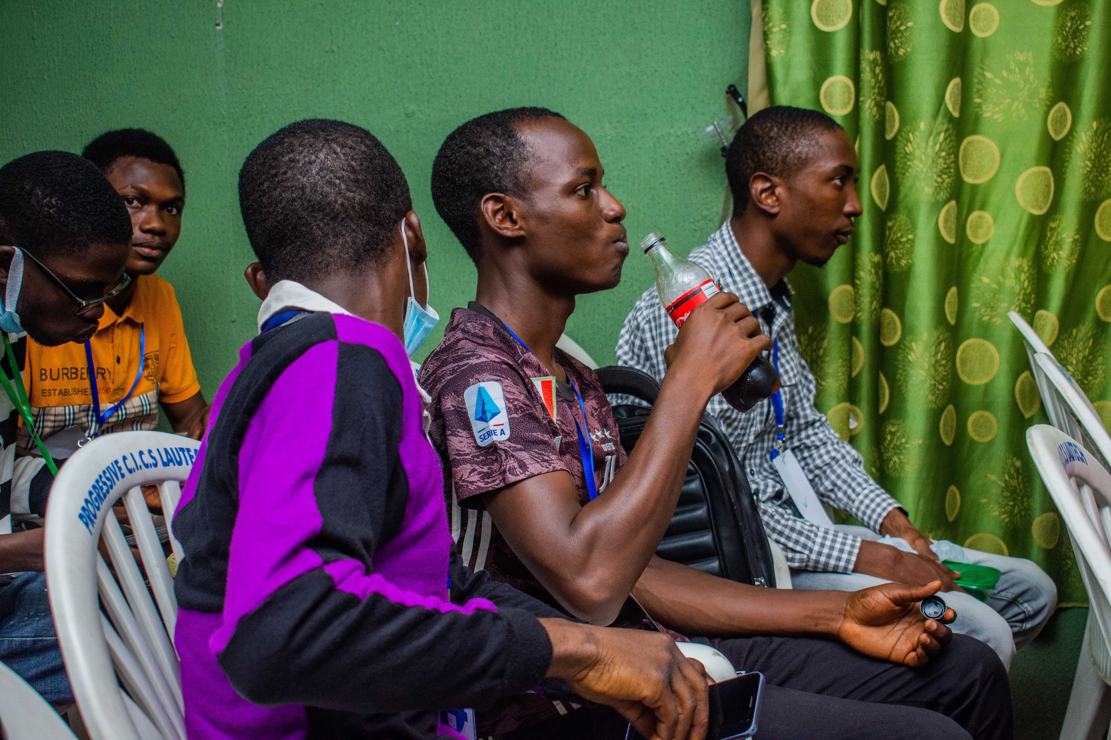 An attendee drinking from a bottle in the audience at DevFest Ogbomoso 2021