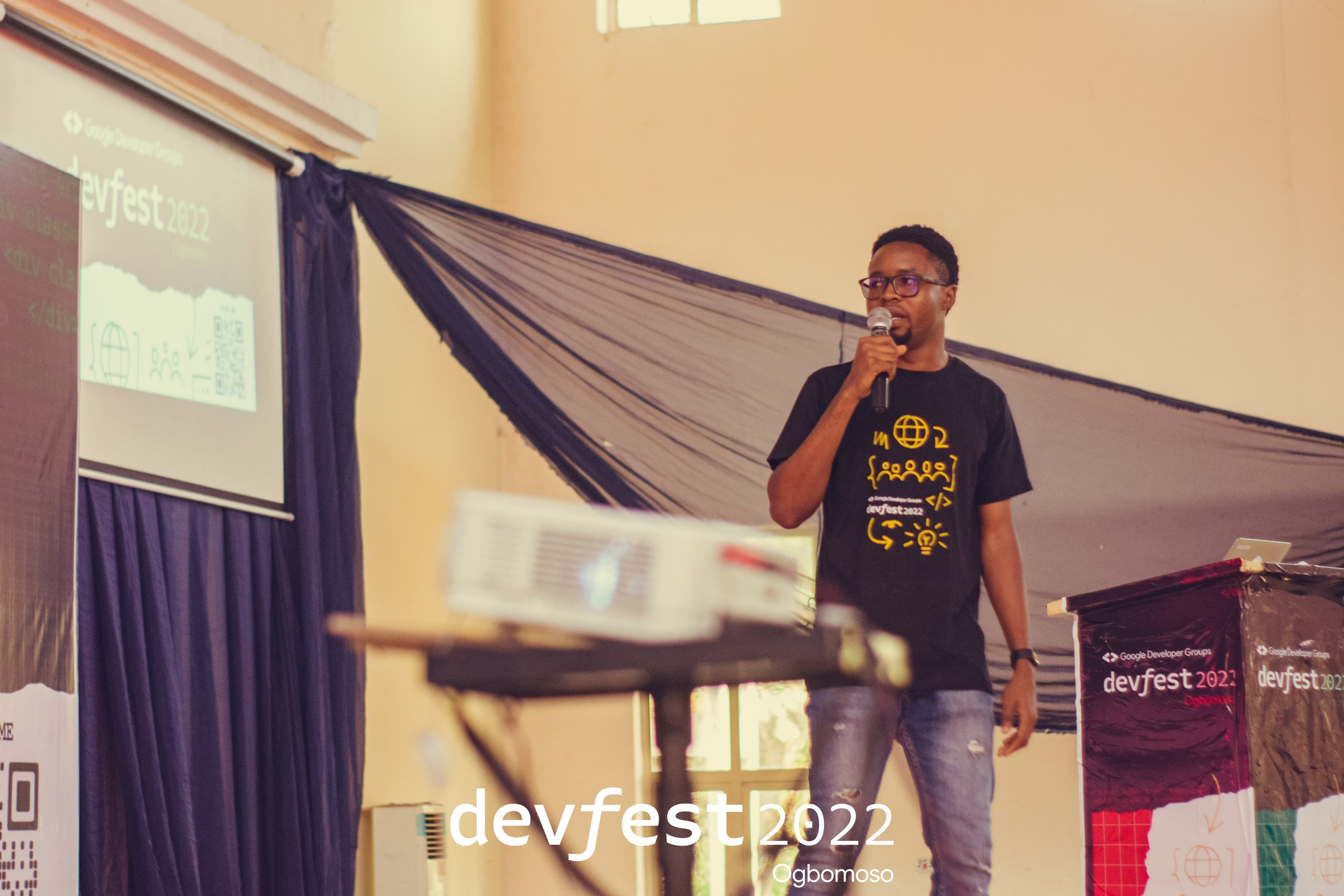 A speaker presenting on the DevFest stage at DevFest Ogbomoso 2022