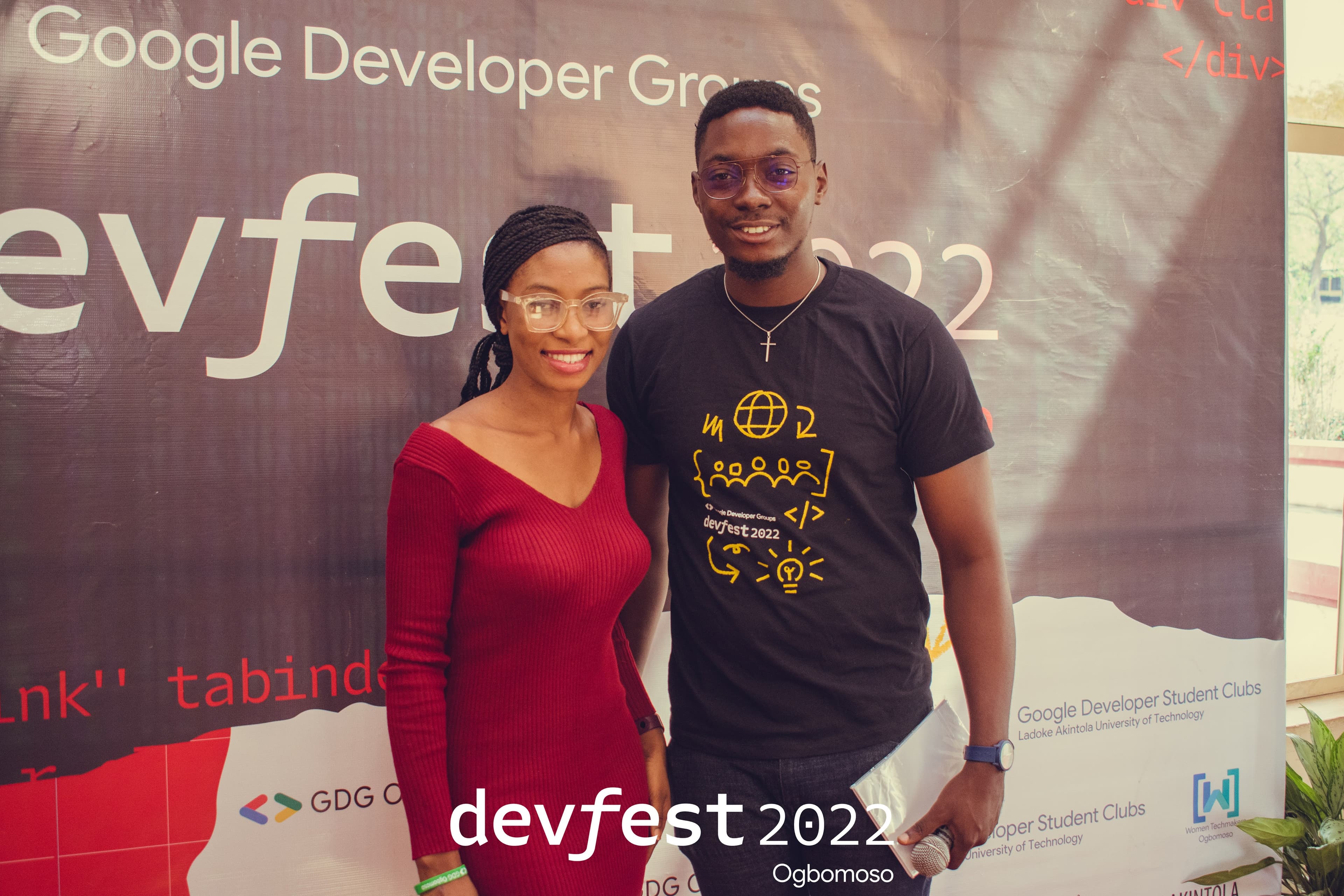 Two attendees at the DevFest backdrop at DevFest Ogbomoso 2022