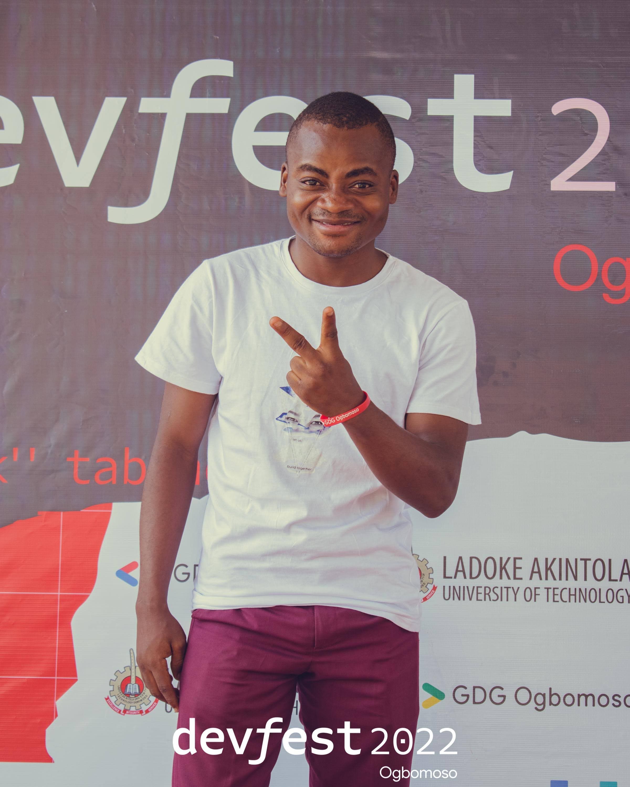 An attendee beside the conference backdrop at DevFest Ogbomoso 2022