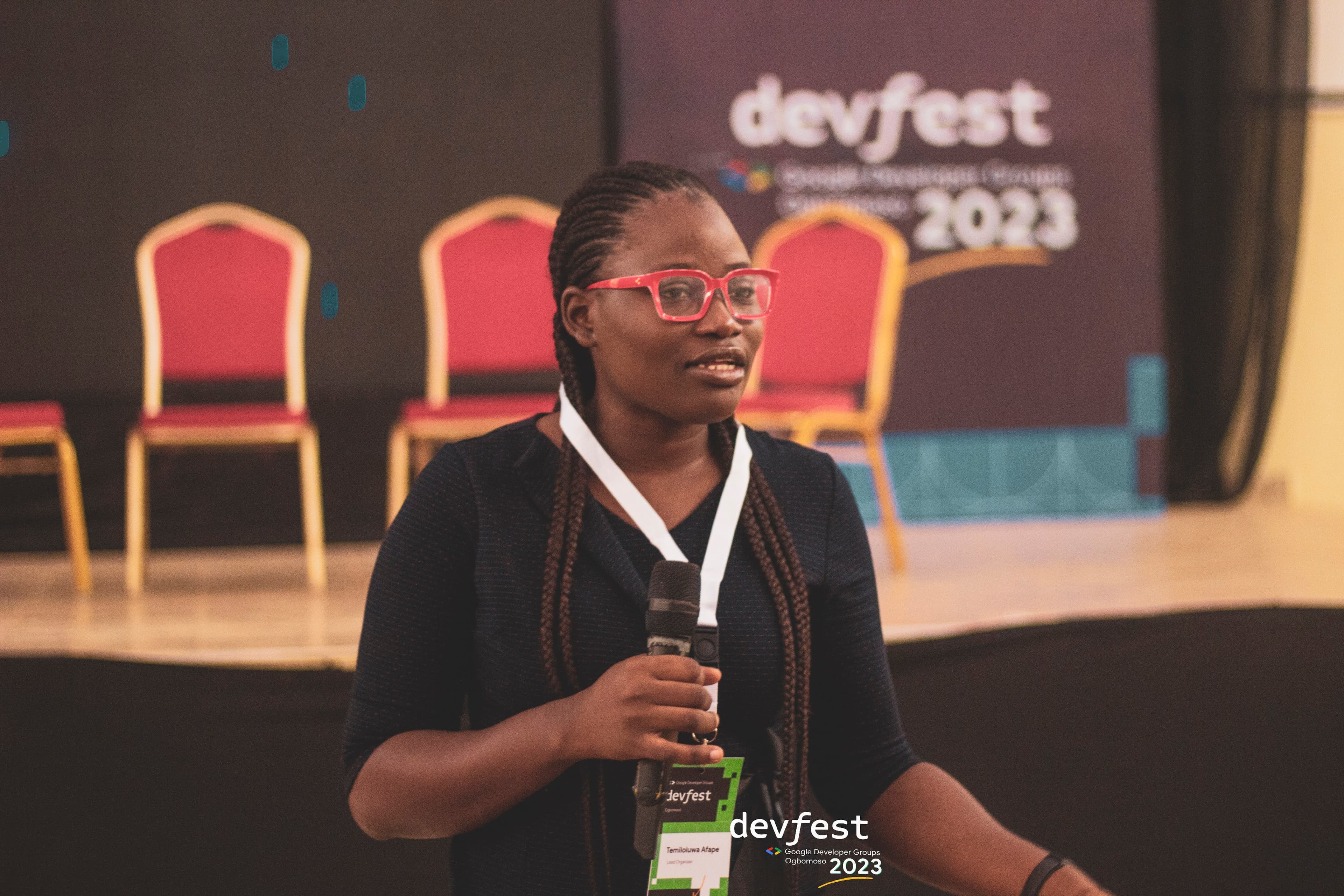 An attendee holding a microphone in front of the stage at DevFest Ogbomoso 2023
