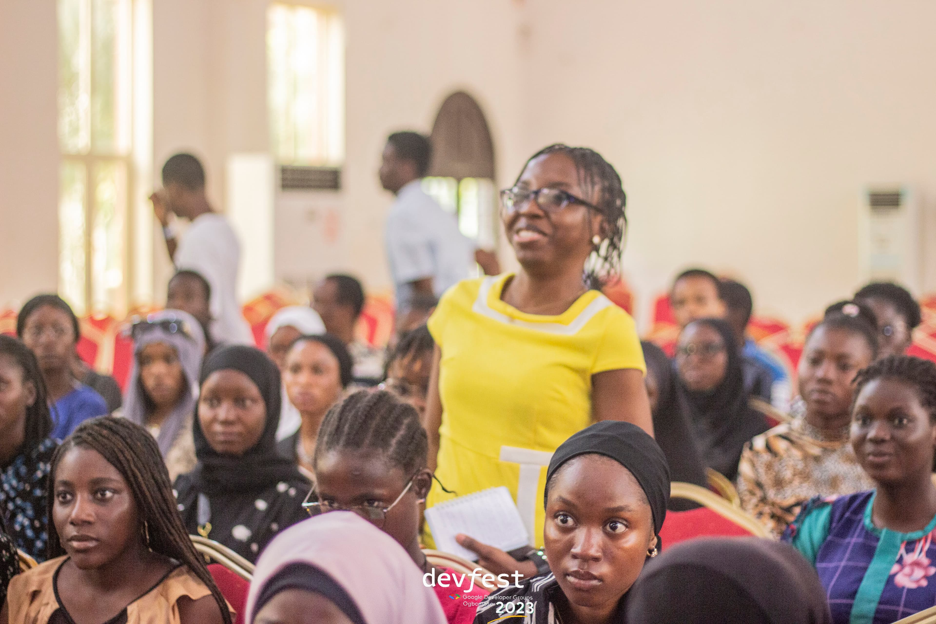An attendee standing among the seated audience at DevFest Ogbomoso 2023