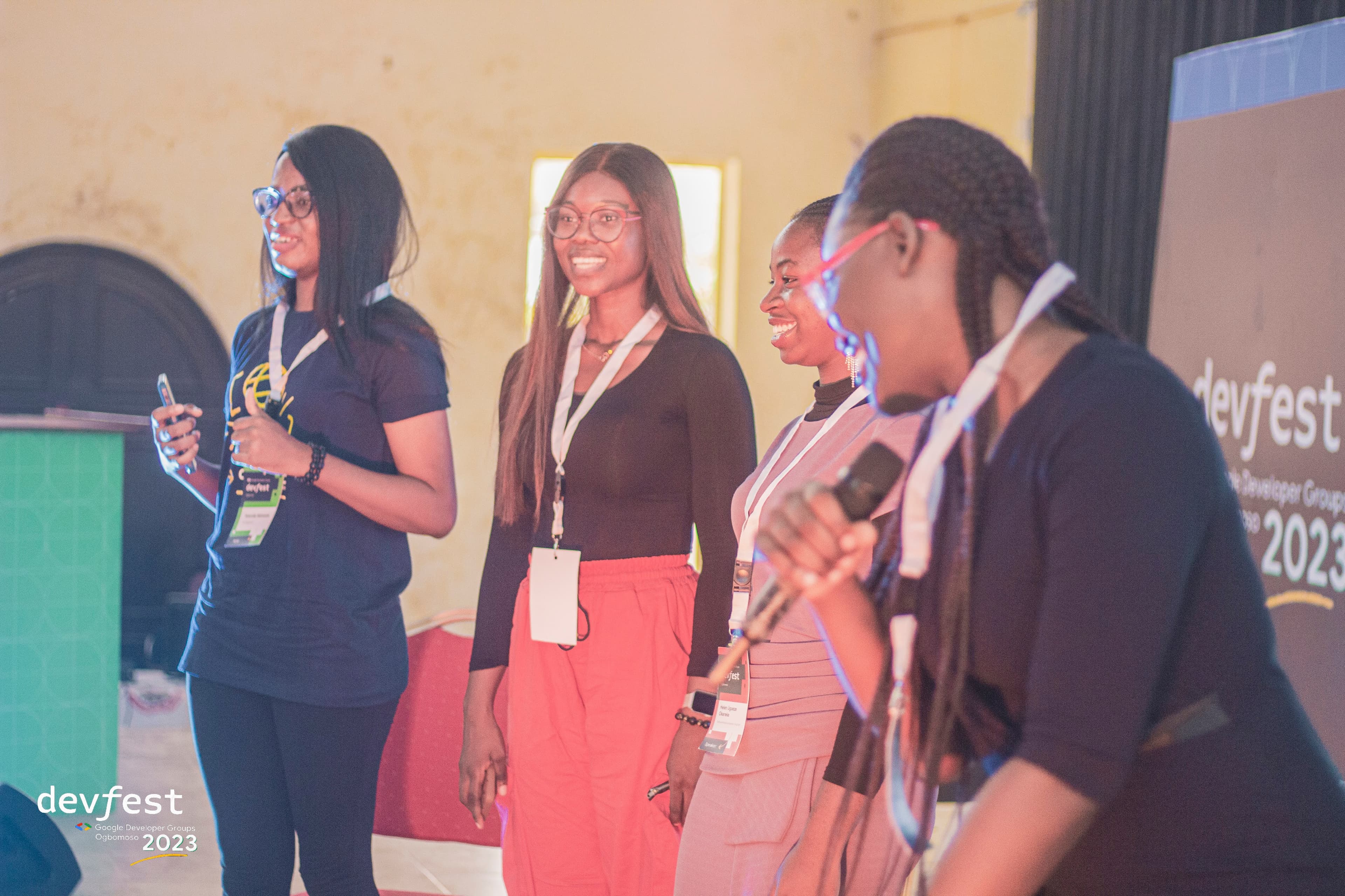 Four people standing on stage, one holding a microphone at DevFest Ogbomoso 2023