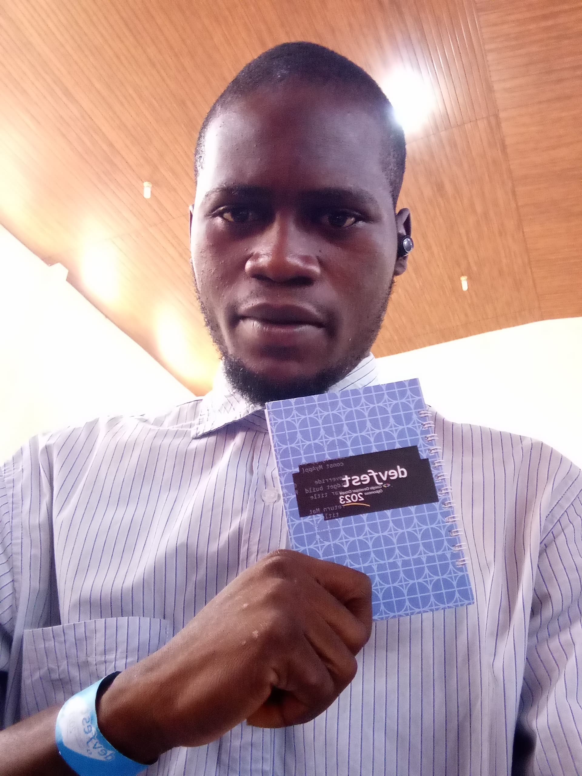 An attendee holding up a DevFest notebook at DevFest Ogbomoso 2023