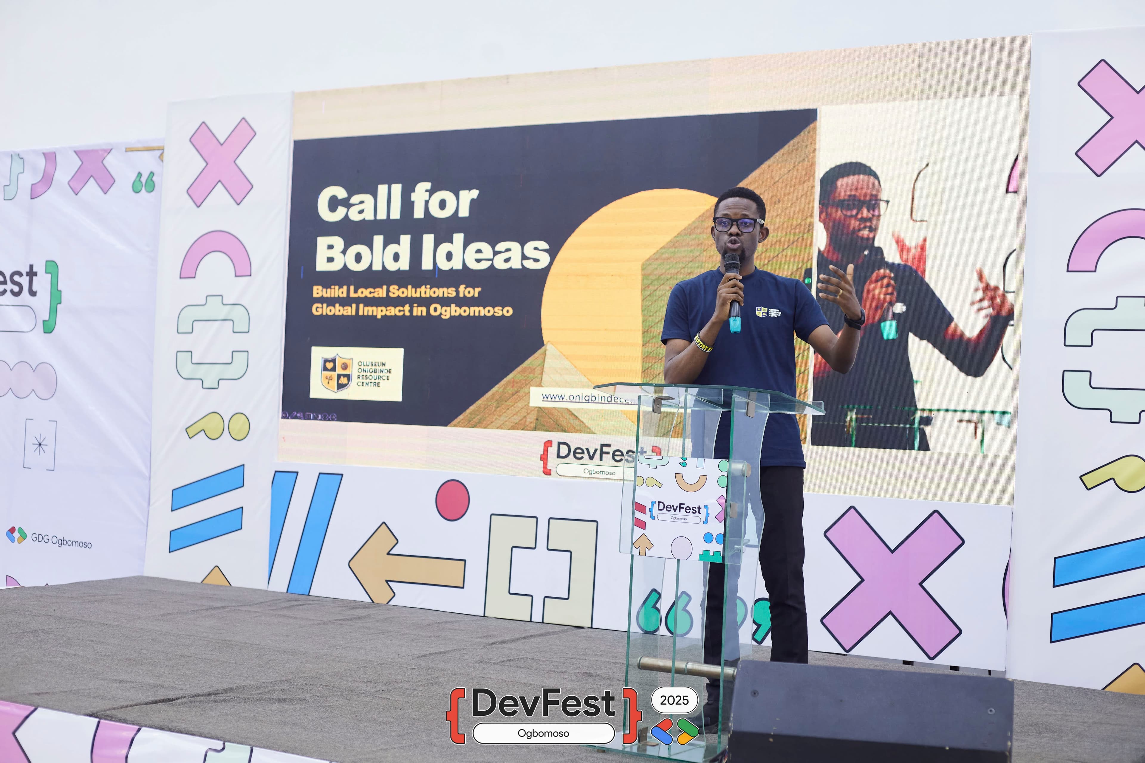 A speaker at the lectern in front of a Call for Bold Ideas slide at DevFest Ogbomoso 2025